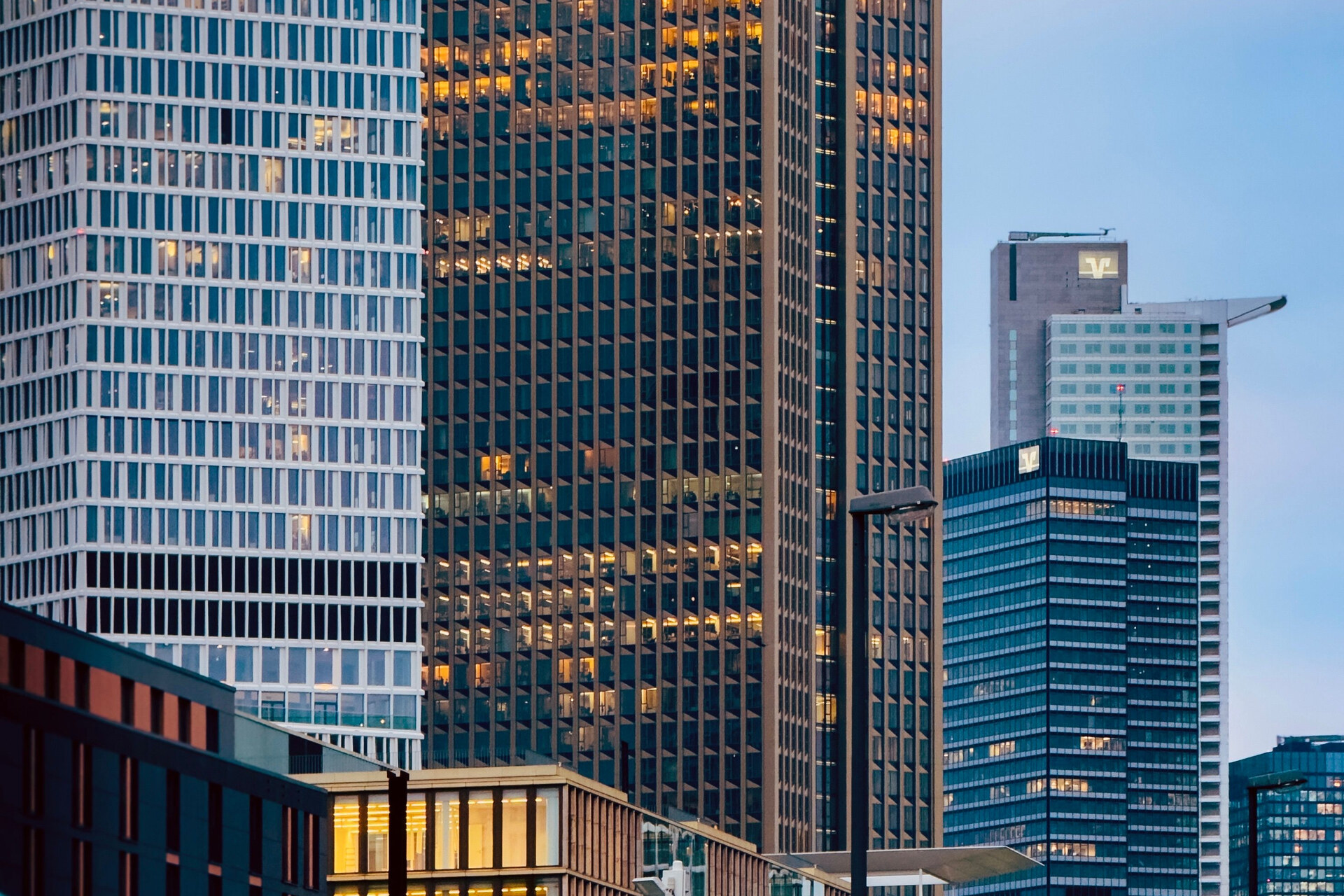 Frankfurt financial district towers at dusk, with illuminated windows