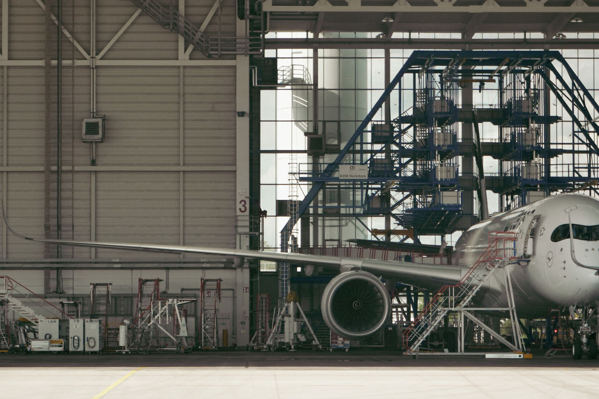 Aircraft in a maintenance hangar with engine, scaffolding and technical equipment