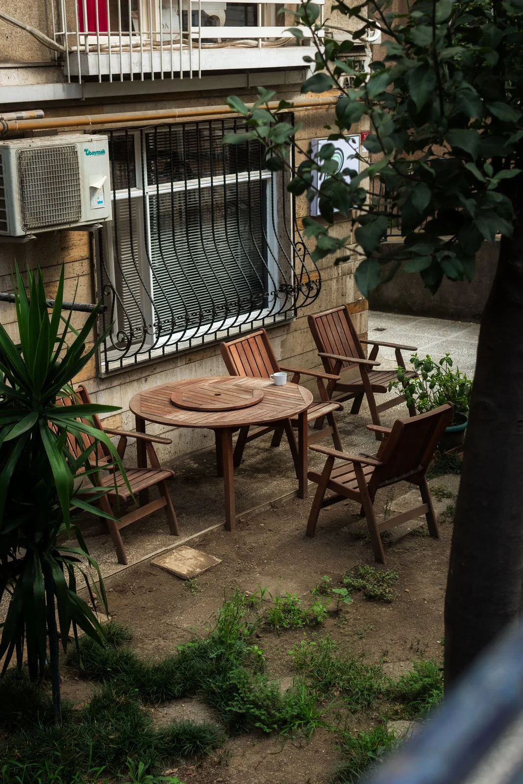 Un tavolo e sedie in un cortile verde, immagine d'atmosfera