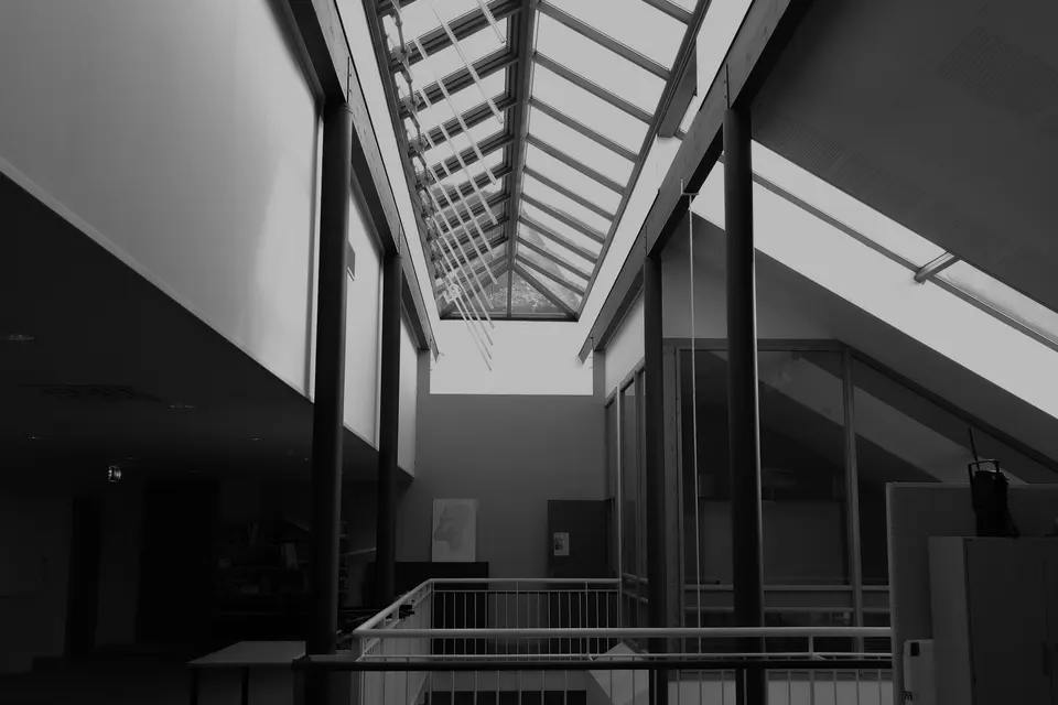 Interno architettonico in bianco e nero con lucernario vetrato e balaustre