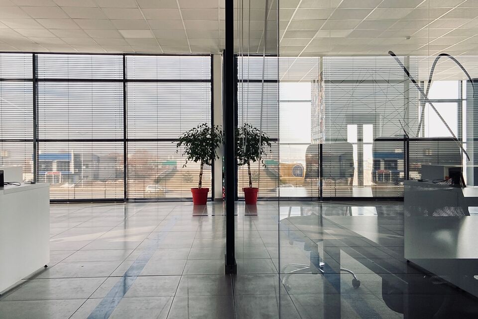 Ufficio luminoso e vuoto con pareti vetrate e grandi finestre